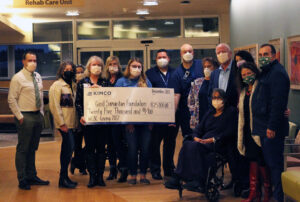 roup of people holding a giant check