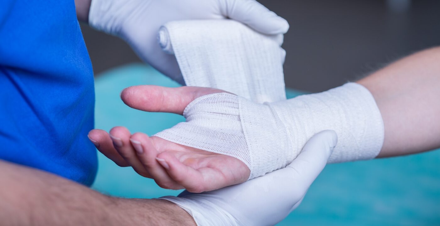Wrist being wrapped in gauze by a health care provider
