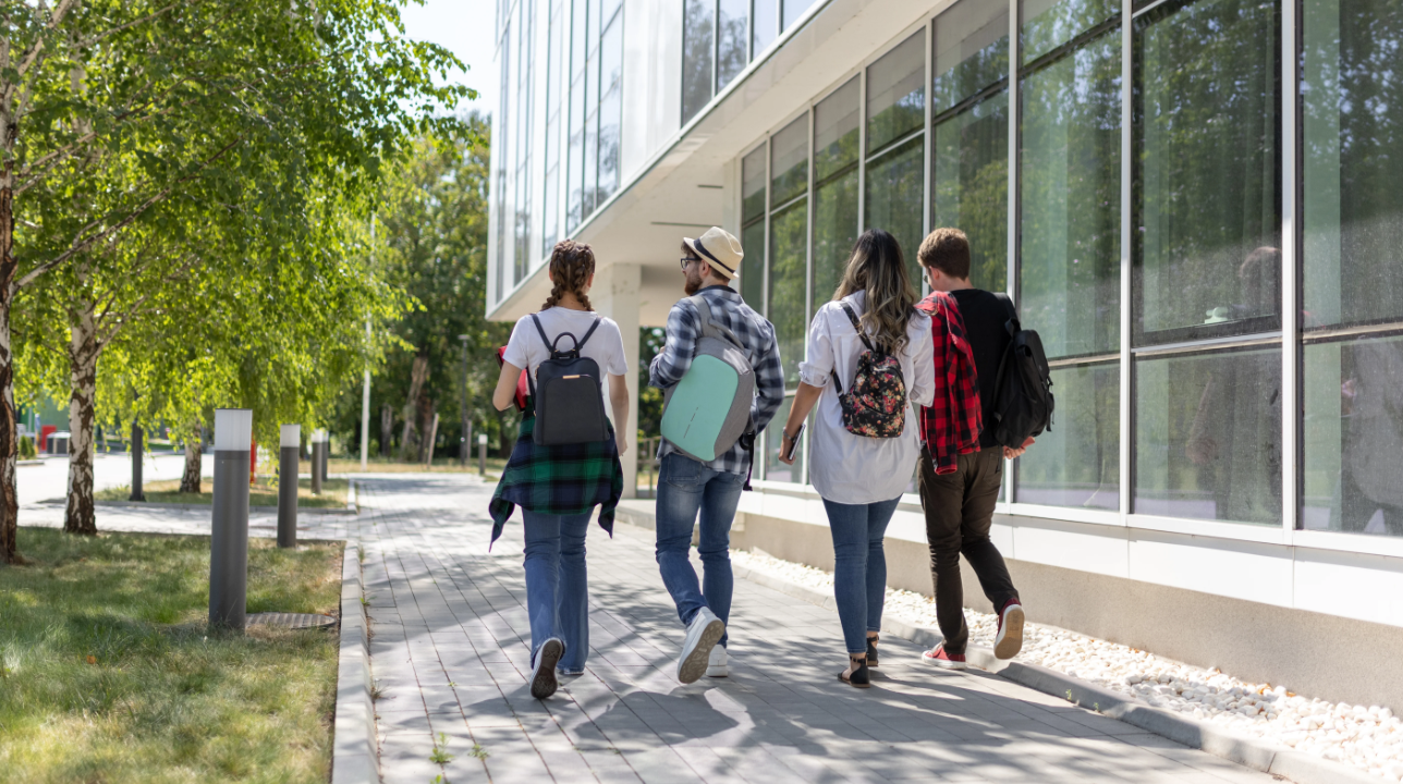 Four individuals walking through what looks like college campus