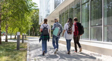 Four individuals walking through what looks like college campus