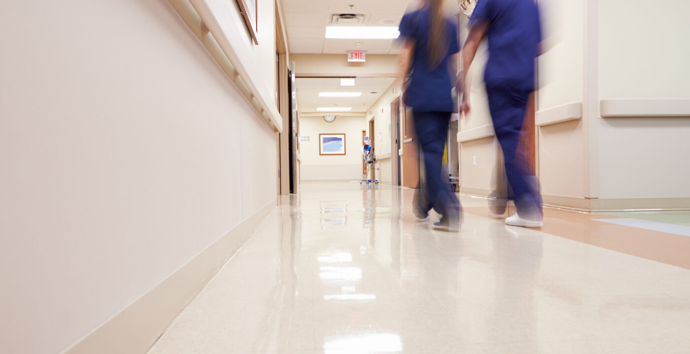 Two nurses walking down hospital hallway