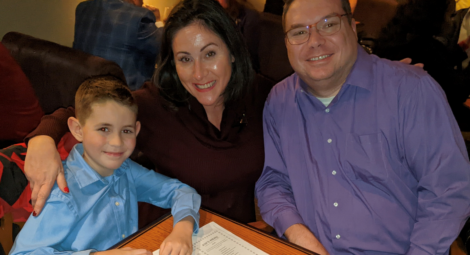 Mom, dad and young son pose for the camera at a table