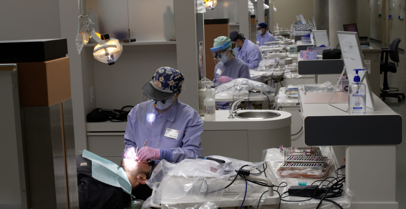Looking down a hallway at dental students working on patients