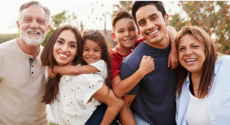 Hispanic presenting multi-generational family posing for photo in park