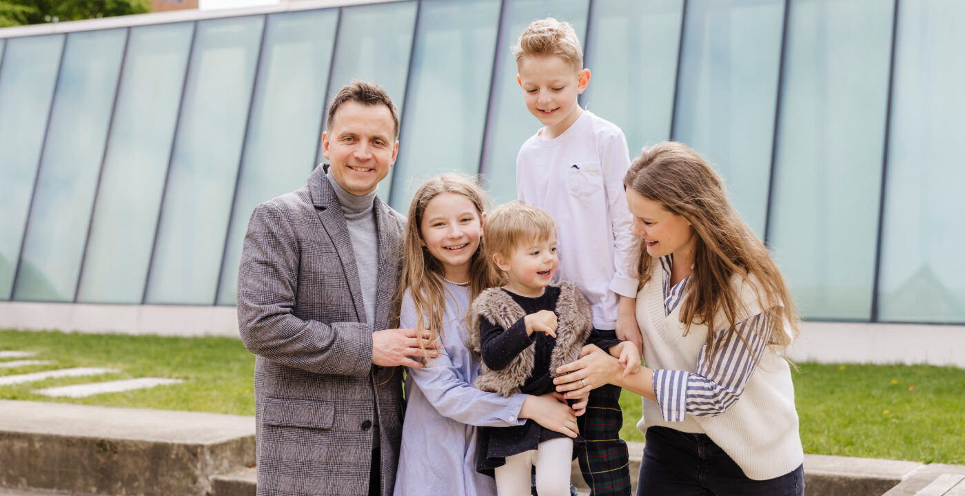 Family sitting on bench poses for camera