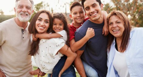 Hispanic presenting multi-generational family posing for photo in park