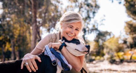 Affectionate woman embracing pet dog in nature