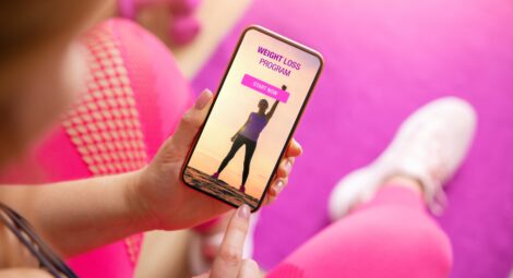 Person looking at smartphone screen with weight loss program displayed