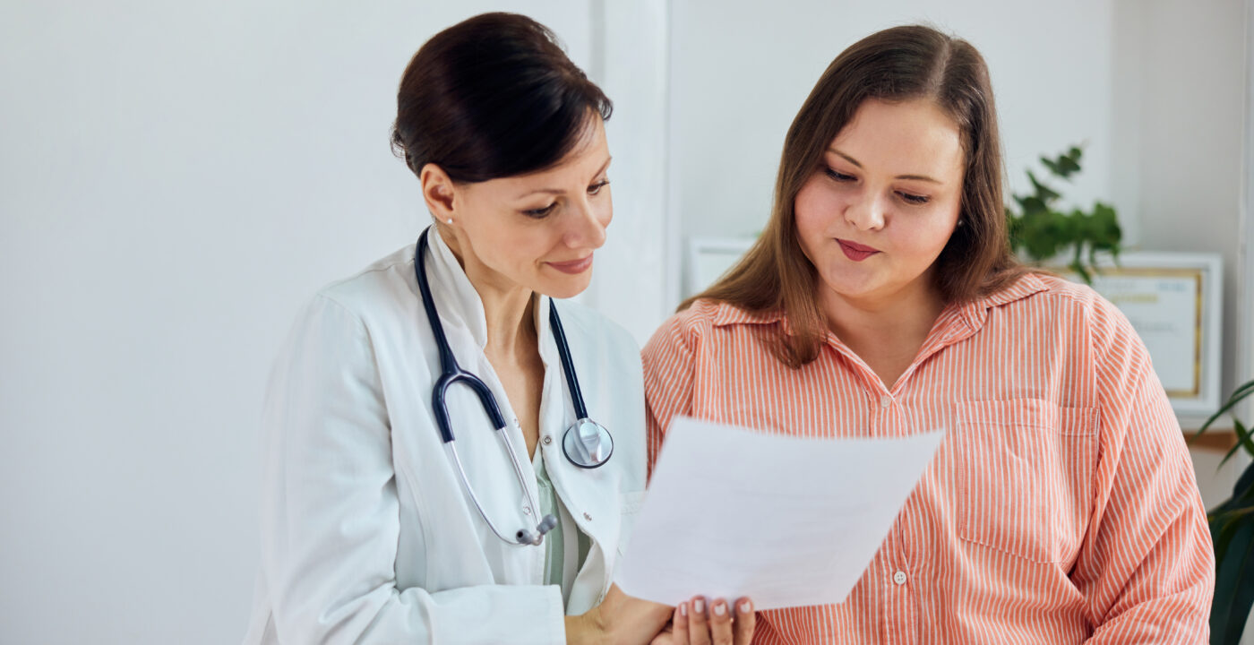 Health care provider looks over a sheet of information alongside a patient