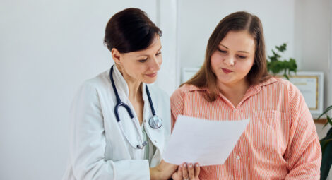Health care provider looks over a sheet of information alongside a patient