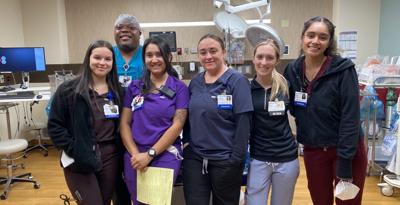 Group of emergency services technicians standing in the trauma room of a hospital