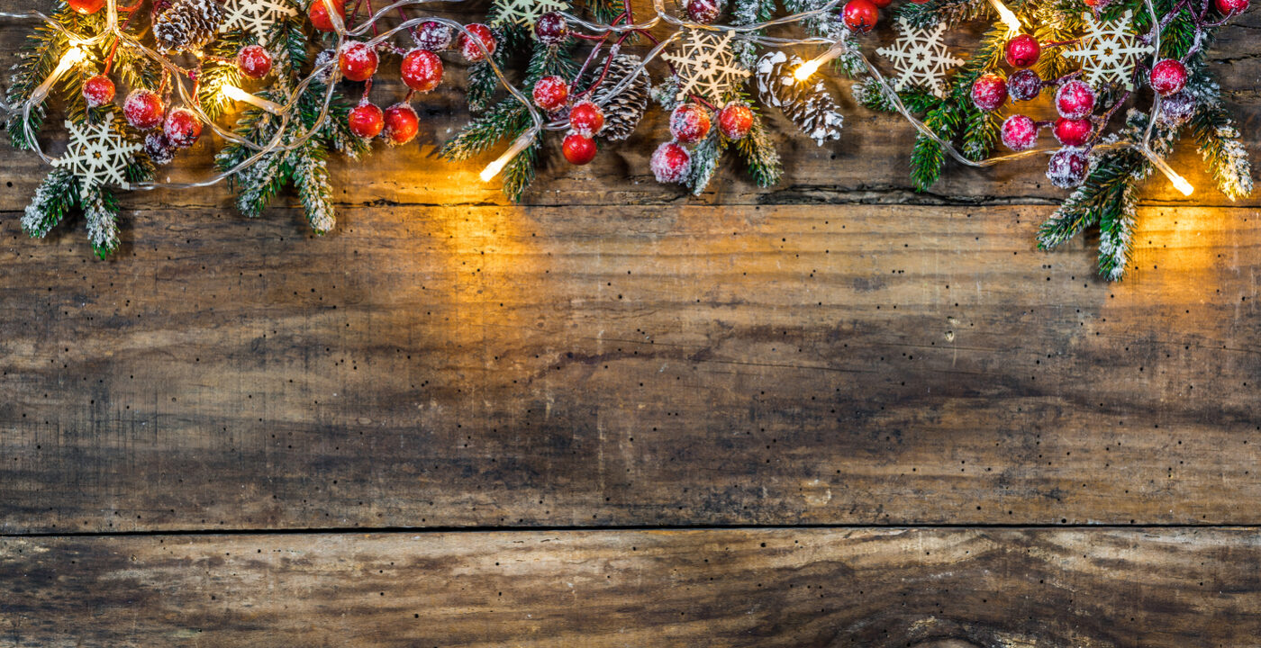 A string of garland and lights against a wood board.