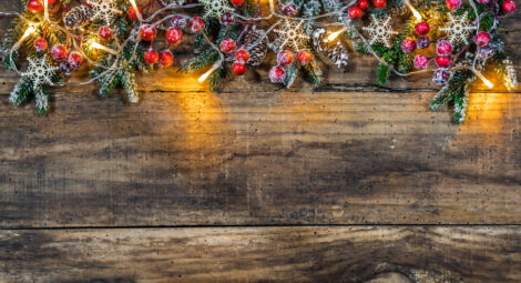 A string of garland and lights against a wood board.