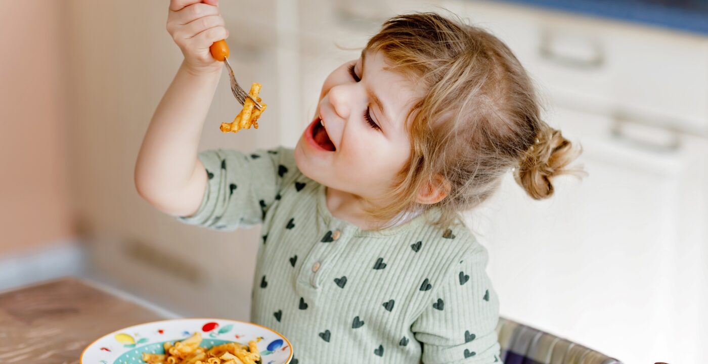Little girl eating pasta