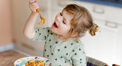 Little girl eating pasta