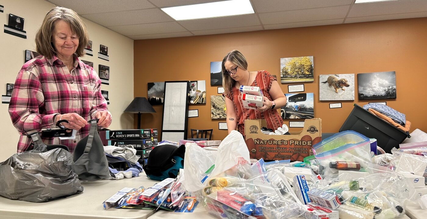 Two women organize donations on a table