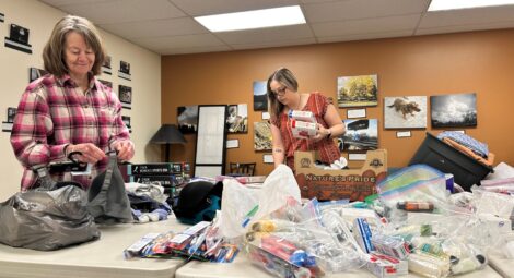 Two women organize donations on a table