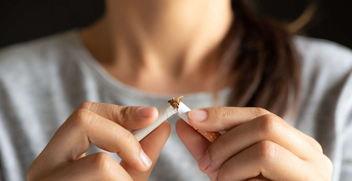 Close-up of hands breaking a cigarette in half