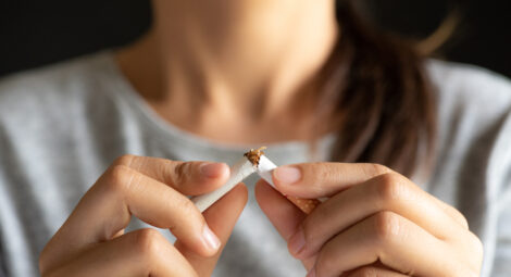 Close-up of hands breaking a cigarette in half