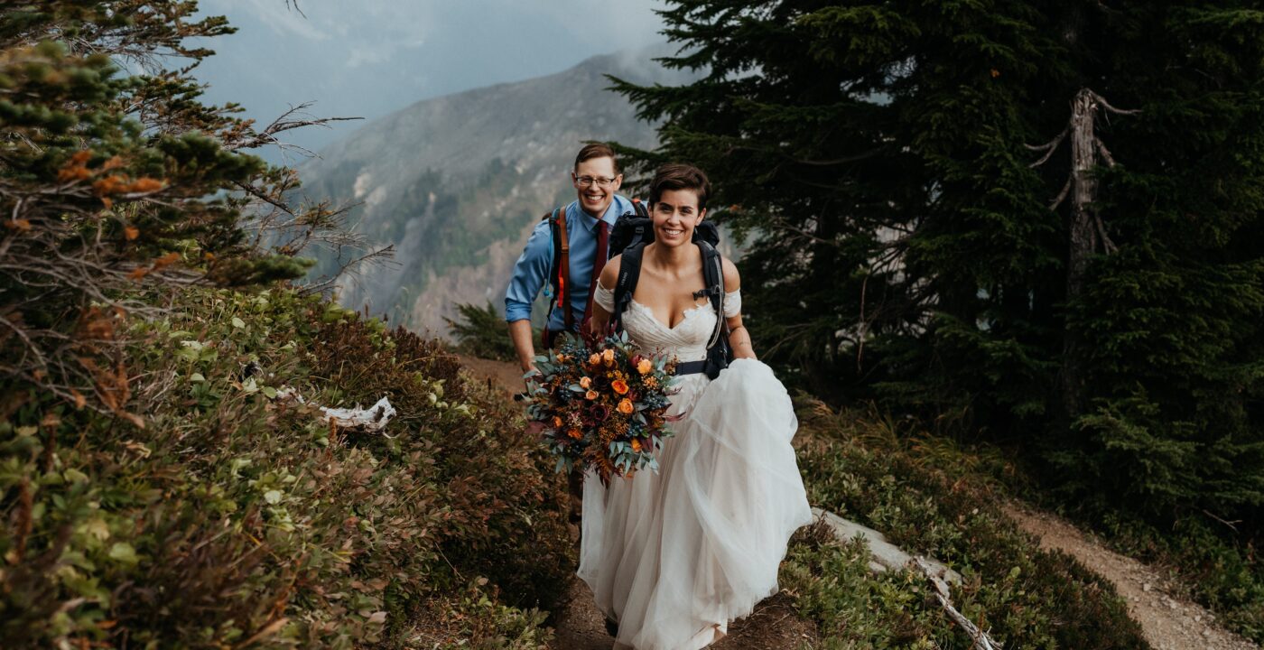 Bride and groom hiking on a mountain trail