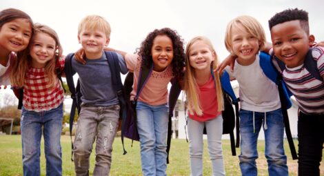 Kids wearing backpacks posing