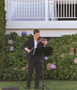 Young man in tuxs playing violin