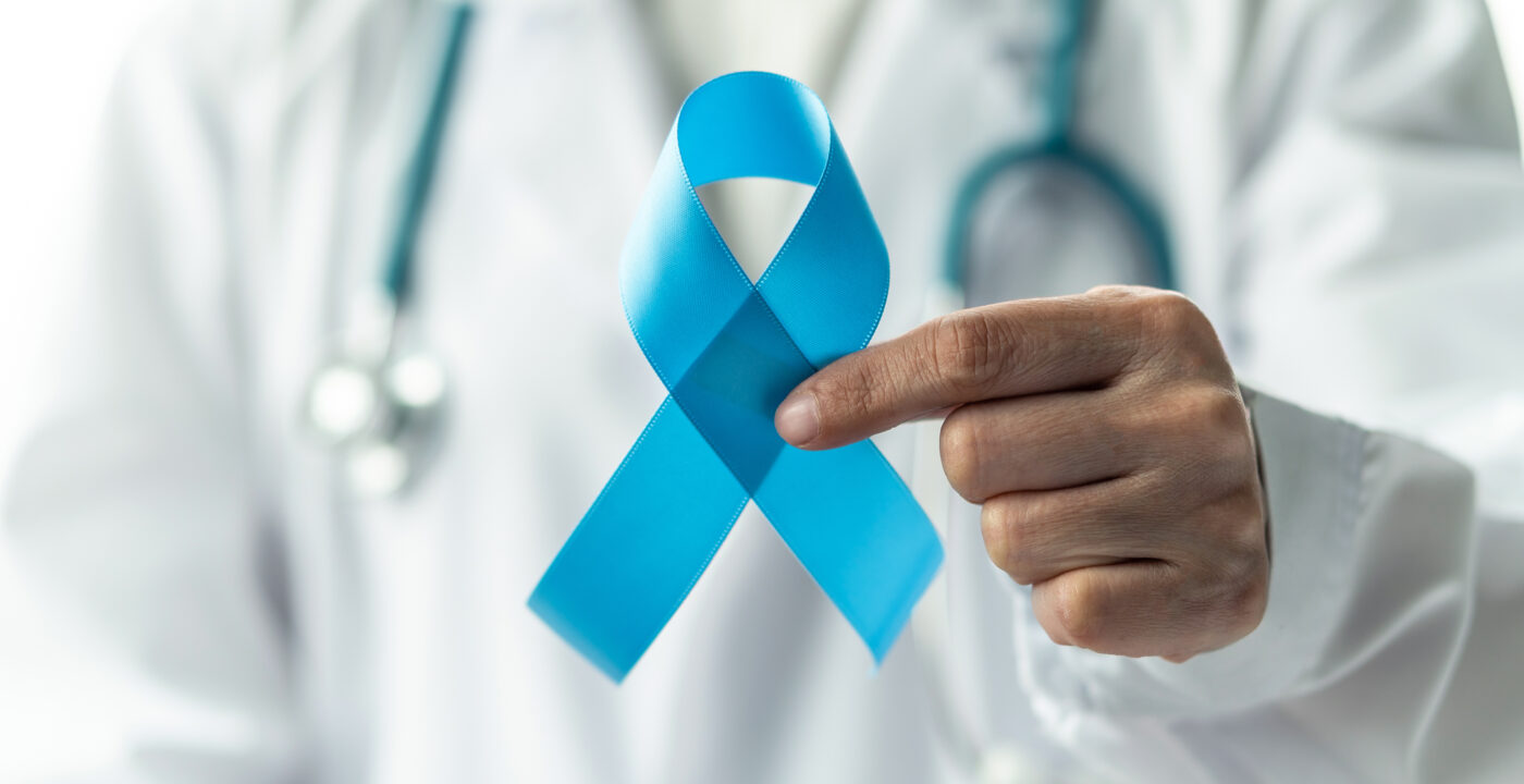 Hand holding a blue ribbon.