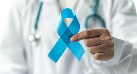 Hand holding a blue ribbon.