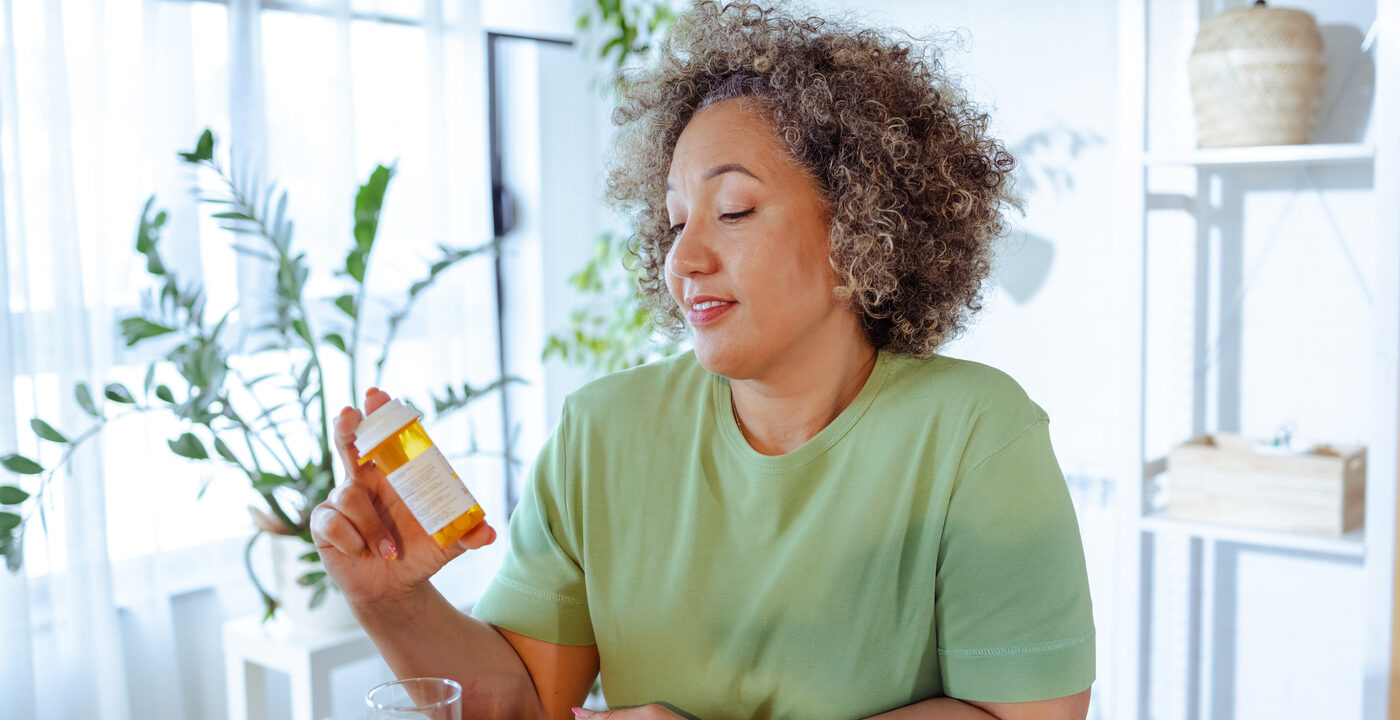 Woman examines pill bottle