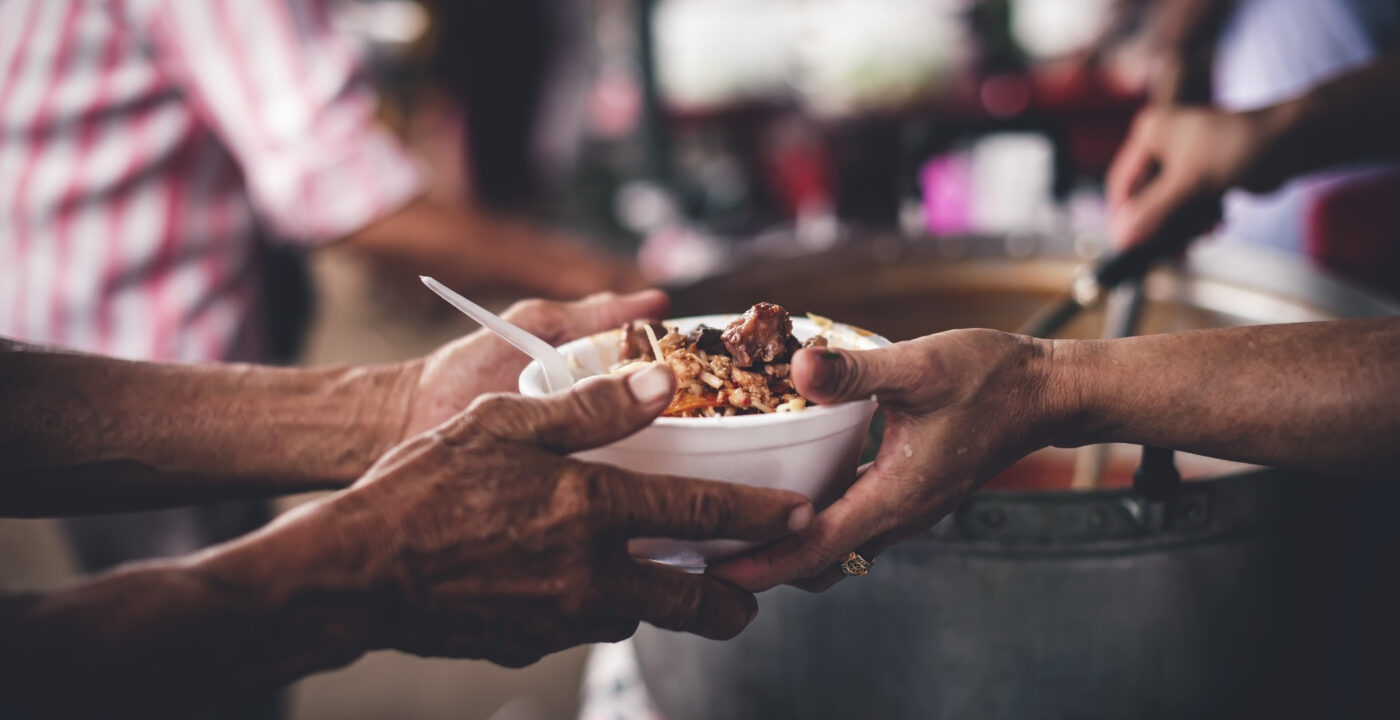 A person handing a bowl of food to another person
