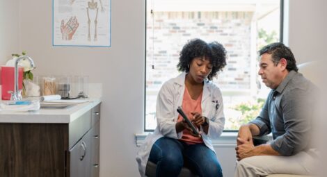 A female doctor showing a male patient something on a tablet