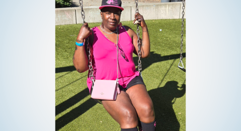 Woman sitting on swing wearing pink top and pink purse