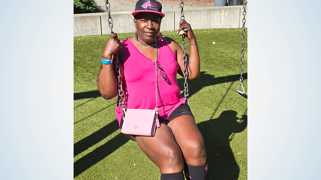 Woman sitting on swing wearing pink top and pink purse