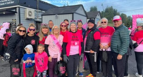 Group of people outdoors, many wearing pink
