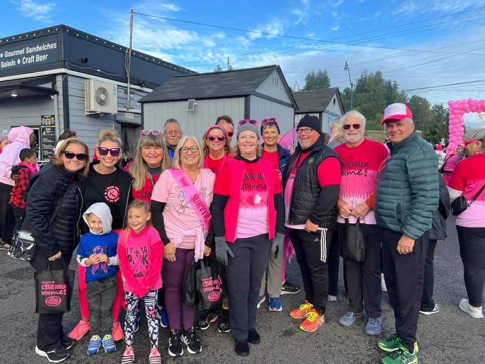 Group of people outdoors, many wearing pink