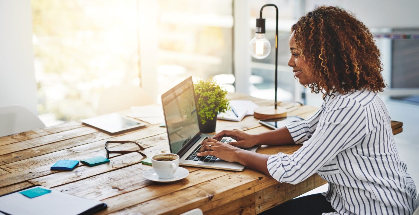 Woman sitting at table typing on computer