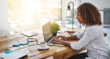 Woman sitting at table typing on computer