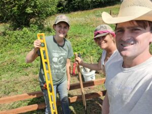 Two women and a man working on farm together