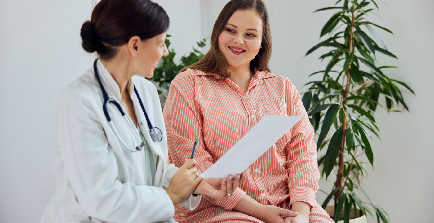 woman in blue striped shirt smiling at doctor