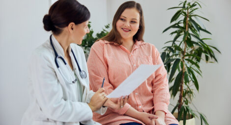 woman in blue striped shirt smiling at doctor