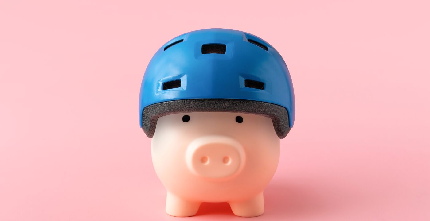 A toy pig in a blue helmet on a pink background