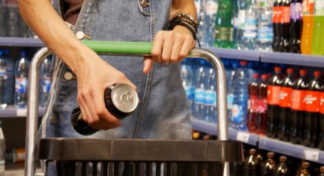 Person holding a canned energy drink while shopping