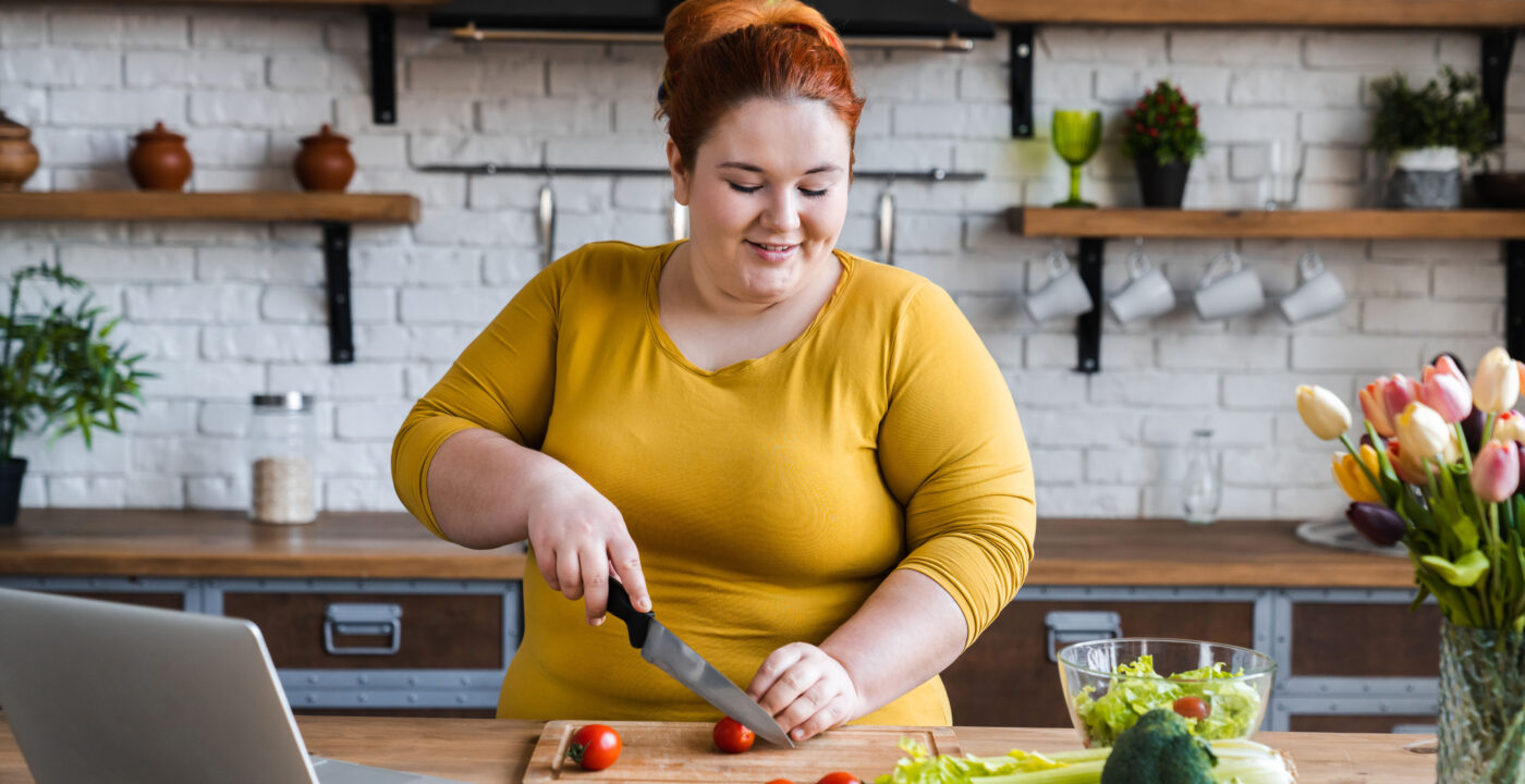 Woman in kitchen chopping vegetables