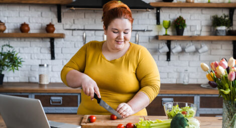 Woman in kitchen chopping vegetables