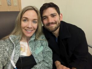 Woman and man smiling at camera during a medical treatment. 