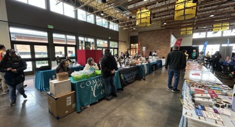 People walk through rows of vendor tables
