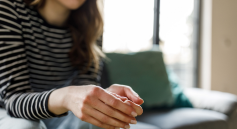 Woman sitting on a couch and cracking her knuckles