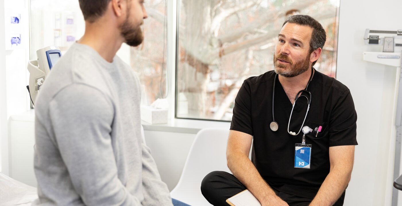 Male patient talking to medical provider in exam room