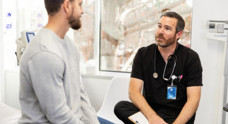 Male patient talking to medical provider in exam room