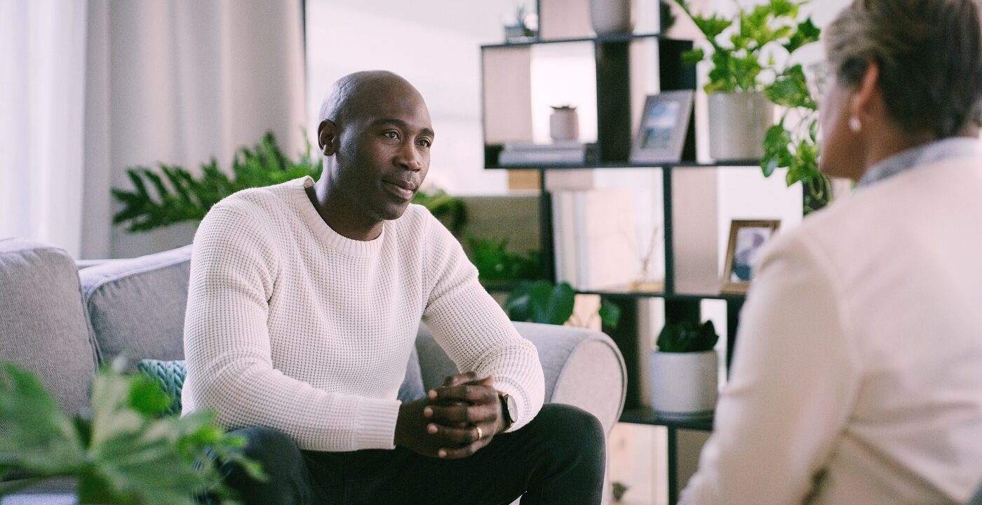Man sitting on a couch across from a therapist